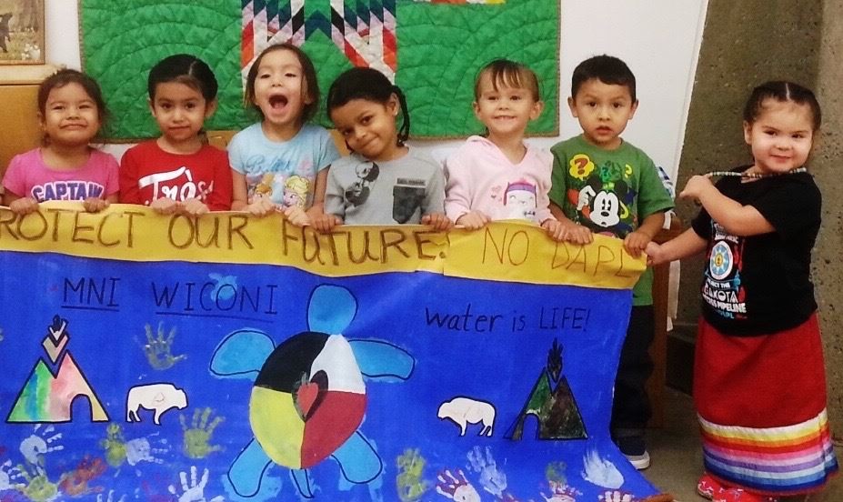Native Montessori Students with the NO DAPL Banner Native Montessori Students with the NO DAPL Banner